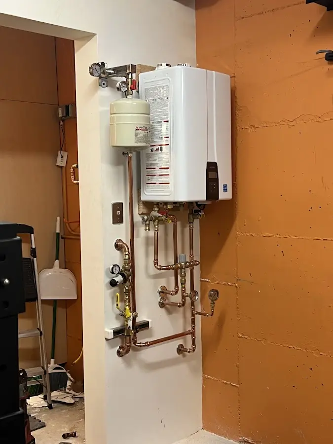 Plumbing technician inspecting water heater connections in Roswell